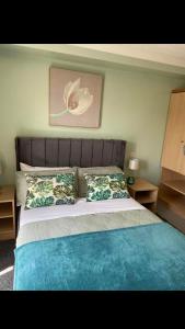 a bedroom with a large bed with blue sheets and pillows at Llanwenarth Hotel in Crickhowell