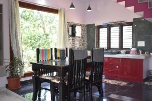 uma cozinha com mesa e cadeiras com livros em Naisarga Hill View em Somvārpet