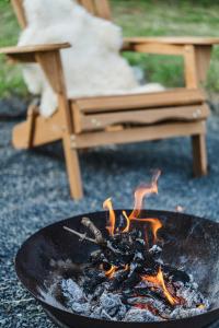 a fire in a grill with a chair in the background at Buborék - Somló Country Home in Somlóvásárhely