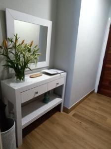 a white table with a mirror and a plant on it at Casa Filo in Redondela