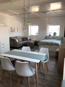 een eetkamer en een woonkamer met een tafel en stoelen bij Traumhaftes Studioappartement in Wadern