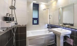 uma casa de banho com uma banheira branca, um lavatório e um espelho. em Hotel Eat Dot Com Alpeuseu Oncheon em Ulsan