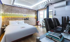 um quarto com uma cama e uma secretária com um computador em Hotel Eat Dot Com Alpeuseu Oncheon em Ulsan