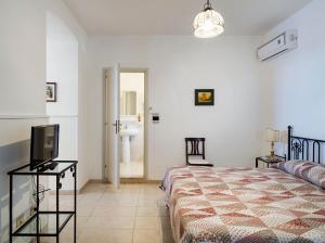 1 dormitorio con 1 cama, TV y baño en Hotel Bel Soggiorno en Taormina