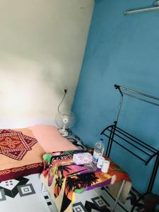 ein Schlafzimmer mit einem Bett und einem Tisch mit einer Lampe in der Unterkunft Grand Mess in Comilla