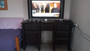 a television on top of a dresser in a bedroom at Studio Hadera in H̱adera