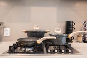 two pots and pans sitting on top of a stove at Sky-Rise Apartments in Los Angeles