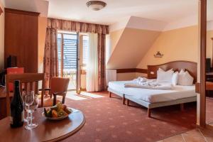 um quarto de hotel com uma cama e uma mesa em Főnix Wellness *** 1 A épület em Hévíz