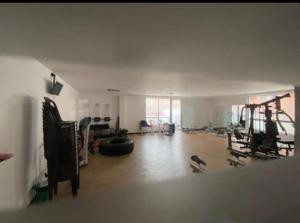 una gran sala de estar con un gimnasio con mucho equipamiento en Depa Privado en Ambiente Residencial Piscina Gimnacio en Bogotá