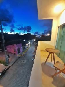 Cette chambre dispose d'une table et offre une vue sur la rue. dans l'établissement Suítes Modernas no Centro da Praia da Pipa, à Pipa