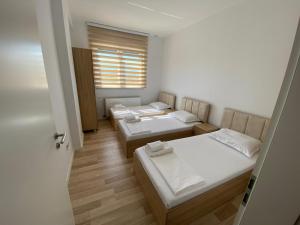 Cette chambre comprend 3 lits et une fenêtre. dans l'établissement Tregu Fatoni #2 prizren city 3 bedroom apartment, à Prizren