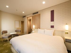 東京にある新宿プリンスホテルのホテルルーム内の大きな白いベッド