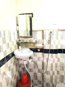 a bathroom with a white sink and a shower at Grand Mess in Comilla