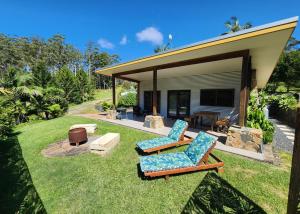 a backyard with two chairs and a patio at Coffs Coast Mountain Retreat Cabin 1 in Coramba