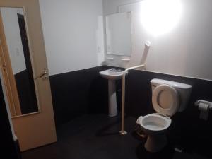 ein Bad mit einem WC und einem Waschbecken in der Unterkunft Hotel Hualum in Villa Dolores