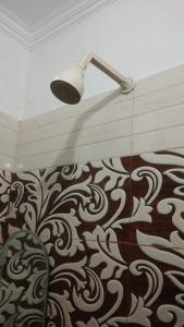 a shower with a light in a room with a wall at Damru Wala Guest House 2min Walking from Ram mandir in Ayodhya