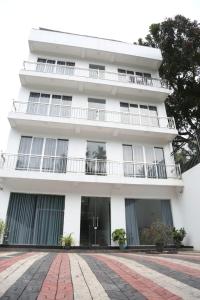 un edificio bianco con balconi e un cortile in mattoni di Qualia Resort a Matara