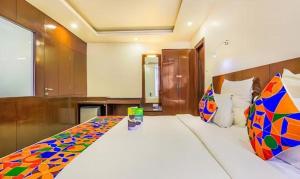 a bedroom with a large bed with a colorful pillow at FabHotel Tipsyy Inn Suites in Jaipur