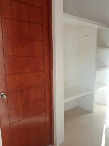 Una puerta de madera en una habitación con armario en Altamar, en Zihuatanejo