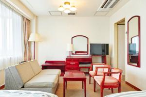 - un salon avec un canapé et une télévision dans l'établissement 砂川パークホテル, à Sunagawa