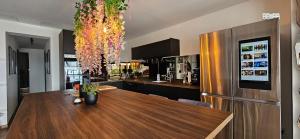 a kitchen with a wooden table and a refrigerator at Bella Piscine in Marseille