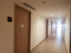 un couloir d'un bâtiment avec une porte et un long couloir dans l'établissement Apartment Embarcardero Bintaro 1BR, à Jombang