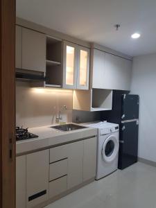 Il comprend une cuisine équipée d'un évier et d'un lave-linge. dans l'établissement Apartment Embarcardero Bintaro 1BR, à Jombang
