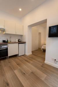 a kitchen with white cabinets and a wooden floor at Madrid, Centro, Cuatro caminos A in Madrid