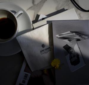 a cup of coffee on a table with a book and a plate at Hotel Onoma Daejeon, Autograph Collection in Daejeon