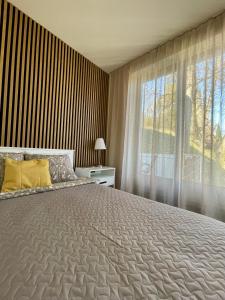 a bedroom with a large bed and a large window at Green Side Apartment in Tartu