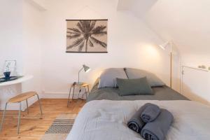 1 dormitorio con 1 cama con una foto de palmera en la pared en Ty Chou - Appartement Cosy - Centre Ville, en Rennes