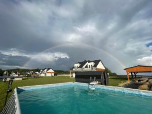 a rainbow in the sky over a swimming pool at Wyspówka in Międzyzdroje