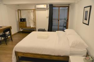 a bedroom with a large white bed with a desk at BPP Resident near Donmueang Airport in Ban Don Muang