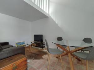 a living room with a glass table and chairs at 28 Casa do Avô - 2Km from the beach in Sesimbra