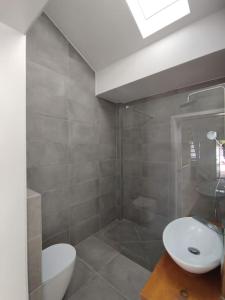 a bathroom with a white toilet and a sink at 28 Casa do Avô - 2Km from the beach in Sesimbra