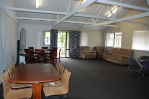 VR Auckland Airport في أوكلاند: غرفة مع طاولة وكراسي وأريكة