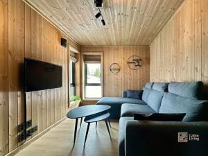 a living room with a blue couch and a table at Brand new cabin in the center of Skeikampen in Svingvoll