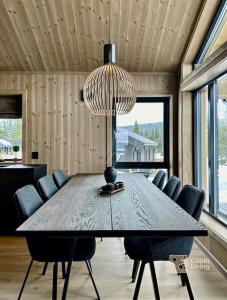 a dining room table with chairs and a chandelier at Brand new cabin in the center of Skeikampen in Svingvoll