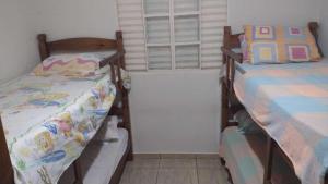 um quarto com 2 camas e uma janela em Espaço acolhedor - Agrishow em São José