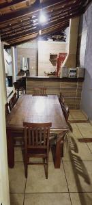 uma grande mesa de madeira e cadeiras num quarto em Espaço acolhedor - Agrishow em São José