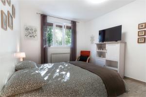 una camera con letto e TV a schermo piatto di Apartment Vinotoč Izola a Izola