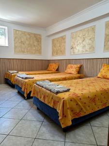 サトゥ・マーレにあるHanul Lui Ionutのオレンジのシーツが敷かれたベッド2台が備わる客室です。