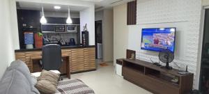 a living room with a couch and a flat screen tv at CASA COMPARTILHADA PERTINHO DO PARQUE ACAUÃ em Garanhuns - Leia atentamente a descricão do imóvel in Garanhuns