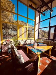 sala de estar con mesa y ventana grande en Adrushya- Suites & Villas by MLS en Mukteswar