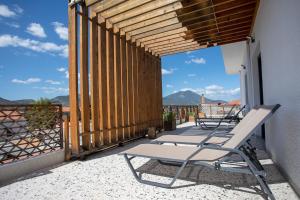 a pair of chairs on a balcony with a view at Aonia Luxurious Modern Boutique Apartments in Chalkida