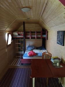 Habitación pequeña con cama y mesa de madera. en Villa Eden Peene Tiny House en Gützkow