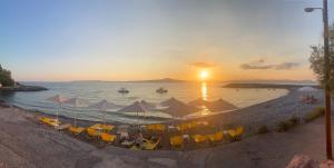 una spiaggia con sedie e ombrelloni al tramonto di Laas ad Avía Altre 3 foto