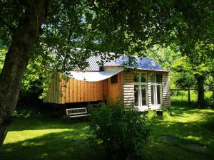 a small wooden cabin in a yard with a tree at Villa Eden Peene Tiny House in Gützkow
