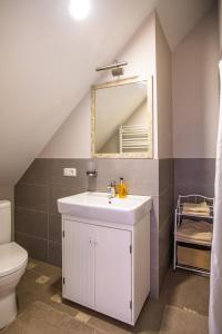 ein Badezimmer mit einem weißen Waschbecken und einem Spiegel in der Unterkunft Villa Nida in Nida