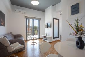 a living room with a couch and a table at Aonia Luxurious Modern Boutique Apartments in Chalkida